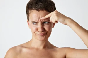 A woman examining forehead wrinkles before a consultation botox vs dermal fillers treatment at Skincare Sommelier Beauty Lab & Med Spa in NYC.