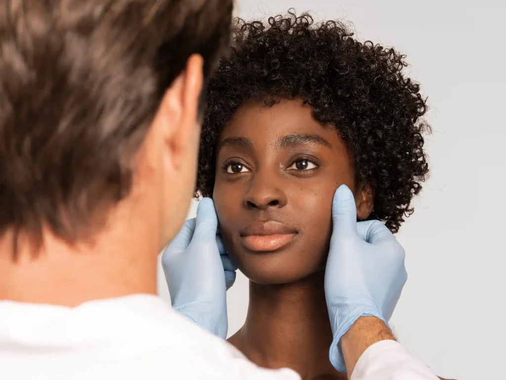 A skincare expert at Skincare Sommelier Beauty Lab & Med Spa evaluating a patient's skin for a microneedling treatment in NYC