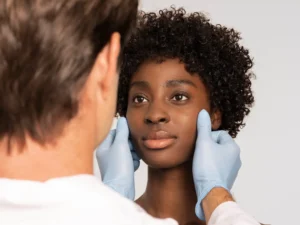 A skincare expert at Skincare Sommelier Beauty Lab & Med Spa evaluating a patient's skin for a microneedling treatment in NYC