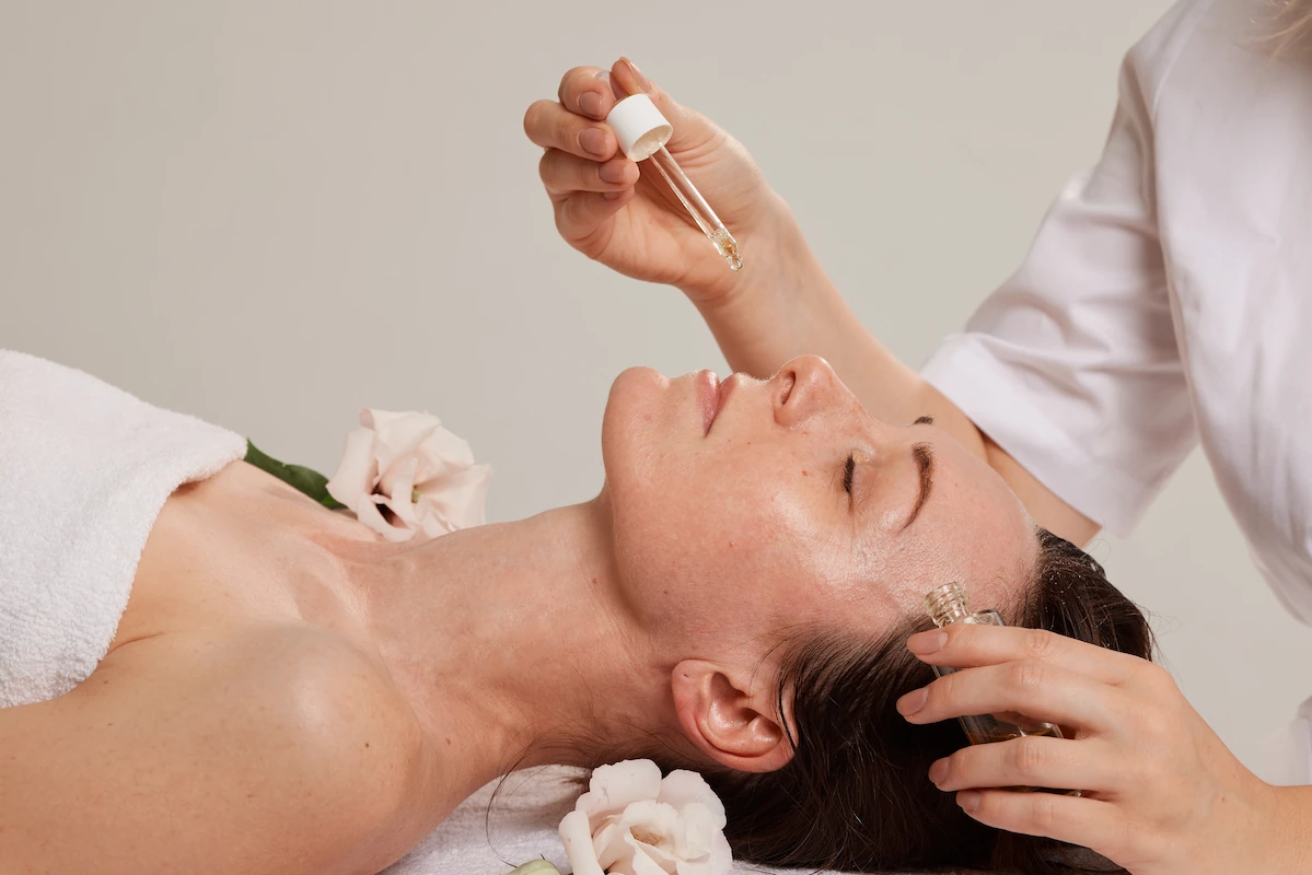 Aesthetician applying PDRN Salmon DNA serum to a patient's face during a skin remodeling treatment